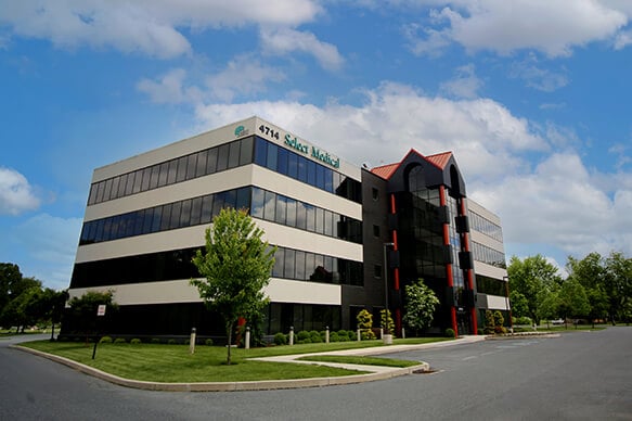 Exterior of the four-story Select Medical corporate office on a sunny day.