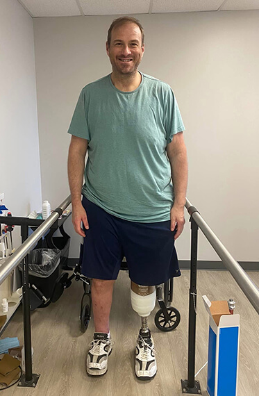 Photo of Kevin standing during therapy with his prosthetic leg